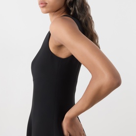 Model wearing Max Mara Studio black sleeveless dress with scoop neckline, fitted silhouette, side split detail visible at hem.