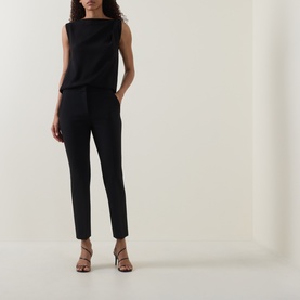 Model wearing Max Mara Main Acino Straight-Leg Trousers in black with pressed creases, styled with a sleeveless black top and strappy heeled sandals.