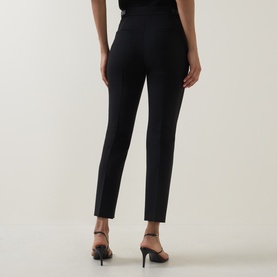 Model wearing Max Mara Main Acino Straight-Leg Trousers in black, slim-fit with pressed creases, styled with black heeled mules