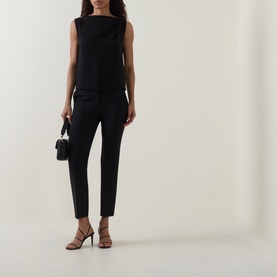 Model wearing Max Mara Main Acino Straight-Leg Trousers in black with matching sleeveless top, styled with strappy heels and small black handbag.
