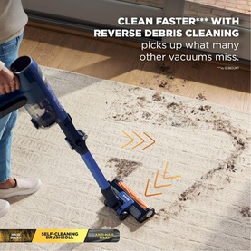 Shark PowerDetect Speed Clean and Empty Pet Pro Cordless Vacuum in blue, cleaning a rug, with reverse debris cleaning feature highlighted