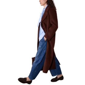 Model wearing Whistles long blue coat, styled with light blue shirt, wide-leg jeans and black loafers