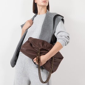Model carrying Stella McCartney Falabella Drawstring Crossbody Bag in mahogany with antique gold chain, styled with grey co-ord set