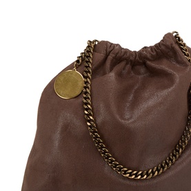 Stella McCartney crossbody bag in mahogany faux leather with gold-tone chain strap and circular logo charm, drawstring top