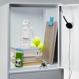 The Ordinary Daily Hydration Bottle in white, styled inside an open locker with books, tennis balls, a clipboard and headphones.
