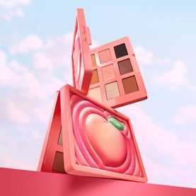 Too Faced Sweet Peach Eye Shadow Palette open compact showing peach-embossed pan and six warm nude-to-brown eyeshadows, pink packaging