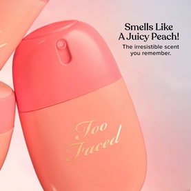 Too Faced Peach Mist Setting Spray in peach-toned bottle with gold script branding and promotional "Smells Like A Juicy Peach" text