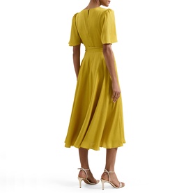 Model wearing Phase Eight yellow midi dress with V-neck, short puff sleeves and full skirt, styled with strappy heeled sandals