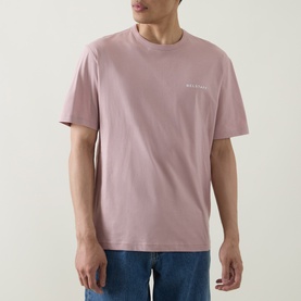 Model wearing Belstaff Border Logo Back Graphic T-Shirt in Dusk Pink, crew neck, short sleeves, styled with blue jeans.