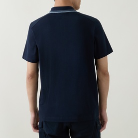 Model wearing Belstaff Alloy Logo Tipped Zip Polo Shirt in Dark Ink, showing rear view with tipped collar detail and short sleeves.