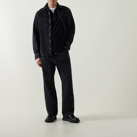 Model wearing Belstaff Alloy Logo Tipped Zip Polo in black, styled with black denim overshirt, wide-leg trousers and black loafers.