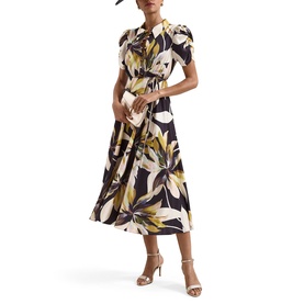 Model wearing Phase Eight black multi floral print midi dress with tie neck and puff sleeves, styled with nude heeled sandals