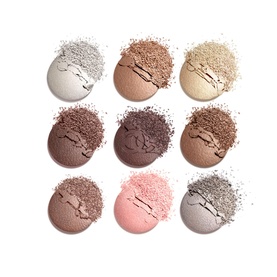 Nine pressed eyeshadow pans in neutral shades including silver, taupe, champagne, brown, mauve, pink and grey, shown smashed with scattered pigment