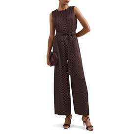 Model wearing Phase Eight brown polka dot sleeveless wide-leg jumpsuit with tie waist, styled with strappy heels and clutch bag