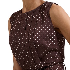 Model wearing Phase Eight brown polka dot sleeveless dress with pleated neckline and tie waist detail
