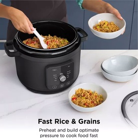 Ninja Hyper Heat 9 in 1 Pressure and Rice Cooker in black, shown in use with cooked rice being served into white bowls