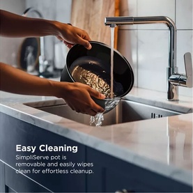 Ninja Hyper Heat 9 in 1 Pressure and Rice Cooker black removable pot being rinsed under kitchen tap, demonstrating easy cleaning.