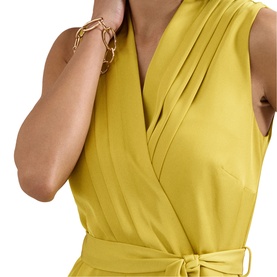 Model wearing Phase Eight yellow sleeveless wrap dress with pleated neckline and tie waist, styled with a gold chain-link bracelet.