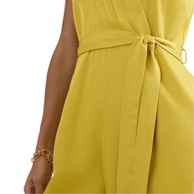 Model wearing Phase Eight yellow sleeveless dress with tie waist belt detail, styled with a gold chain bracelet
