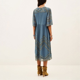 Model wearing Bash blue midi dress with gold embroidery detail, styled with tan suede ankle boots