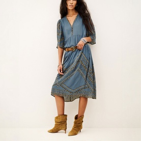 Model wearing Bash blue midi dress with boho print trim and V-neckline, styled with tan leather belt and suede ankle boots