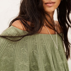Model wearing Bash green textured pointelle knit top with off-shoulder neckline and flared sleeves, styled with a delicate chain necklace