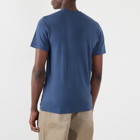 Model wearing Acne Graphic Logo T-Shirt in navy, rear view, crew neck, short sleeves, straight hem, styled with beige trousers.