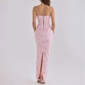 Model wearing House of CB pink strapless maxi dress with floral jacquard, lace-up back detail and centre back split, rear view.