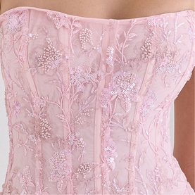House of CB pink strapless corset top with floral embroidery, sequin detail, and pearl bead embellishments on sheer overlay
