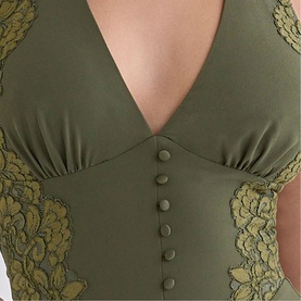 Model wearing House of CB olive bodysuit with gold lace side panels and button-front corset detail