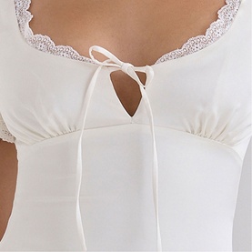 Model wearing House of CB ivory corset top with lace trim neckline and tie-front detail, close-up view.
