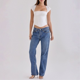 Model wearing House of CB white lace-trim square-neck crop top with cap sleeves, styled with mid-blue straight-leg jeans