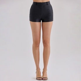 Model wearing House of CB black high-waisted satin mini shorts, styled with nude strappy heeled sandals