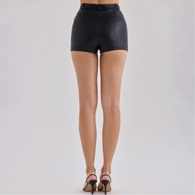 Model wearing House of CB black faux leather mini shorts, styled with strappy heeled sandals, rear view