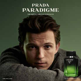 Prada Paradigme refillable fragrance bottle in dark green glass with silver cap, shown in campaign image with male model