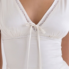 House of CB ivory top with V-neckline, lace trim detailing, and ribbon tie under the bust.