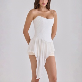 Model wearing House of CB white strapless mini dress with ruched bodice and asymmetric layered mesh skirt