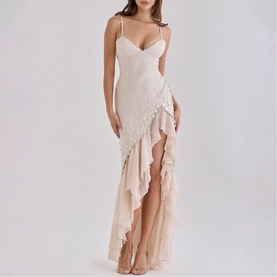 Model wearing House of CB almond maxi dress with spaghetti straps, ruffle hem, thigh-high split and pearl embellishments