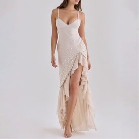 Model wearing House of CB almond maxi dress with spaghetti straps, wrap bodice, pearl embellishments, and asymmetric ruffle hem