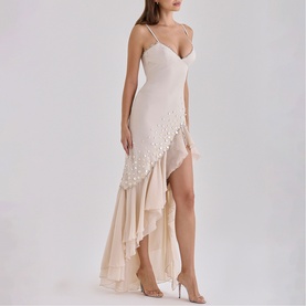 Model wearing House of CB almond asymmetric midi dress with spaghetti straps, pearl-trim hem detail, and tiered ruffle skirt, styled with heeled