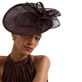 Model with Phase Eight brown wide-brim sinamay fascinator hat with bow and feather detail, styled with matching halterneck top