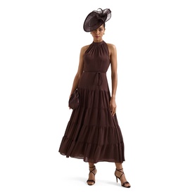 Model wearing Phase Eight brown halterneck tiered midi dress, styled with brown heels, clutch bag and fascinator hat