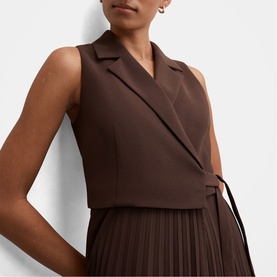 Model wearing Forever New Chocolate Freckle sleeveless wrap dress with notch lapel and pleated skirt, close-up detail view