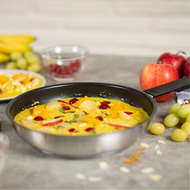 Kuhn Classic Induction Five-Piece Cookware Set stainless steel frying pan with non-stick coating, shown with fresh fruit dish styled on grey surface