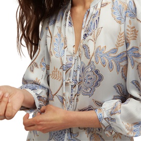 Model wearing Hobbs blue multi floral print blouse with tie neckline and blouson sleeves, close-up detail shot