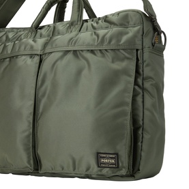 Porter Yoshida sage green nylon briefcase with quilted exterior, front zip pocket, dual top handles, and branded label detail
