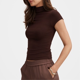 Model wearing Forever New chocolate short-sleeve mock-neck top, styled with matching wide-leg trousers and gold cuff bracelet.
