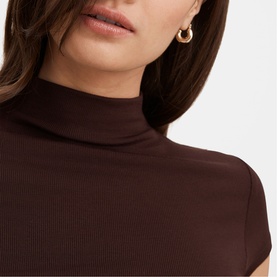 Model wearing Forever New chocolate ribbed turtleneck top with cap sleeves, styled with gold hoop earrings