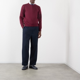 Model wearing Thom Browne burgundy cotton sweatshirt with navy wide-leg trousers, check shirt, and black loafers