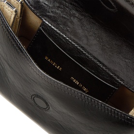 Wandler Black Glaze leather clutch bag, interior view showing gold-tone brand stamp and beige suede lining